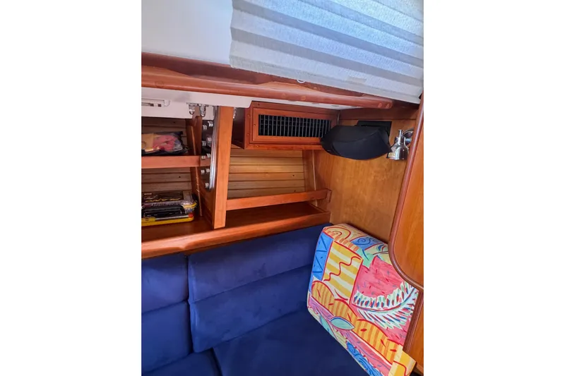 Lady Slipper Yacht Photos Pics Interior of 2005 Sabre 386 sailboat with wooden shelves and colorful cushion.