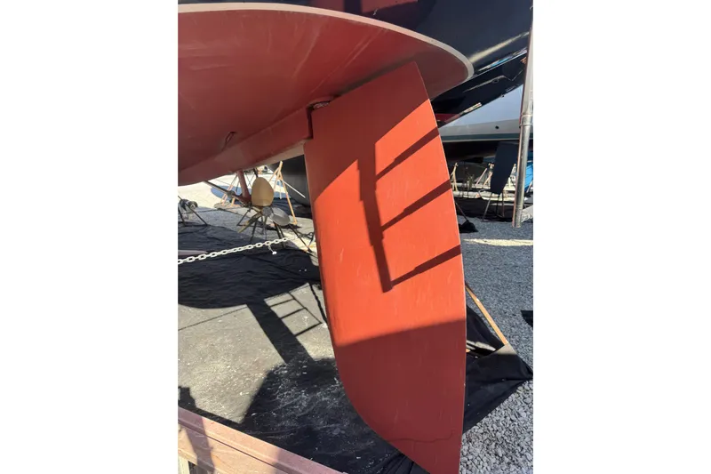 Lady Slipper Yacht Photos Pics Rudder of 2005 Sabre 386 sailboat on dry dock, showing red paint and shadow.