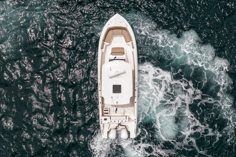Southern Pass Yacht Photos Pics Aerial view of 2019 Pursuit S 328 Sport boat cruising on ocean waves.
