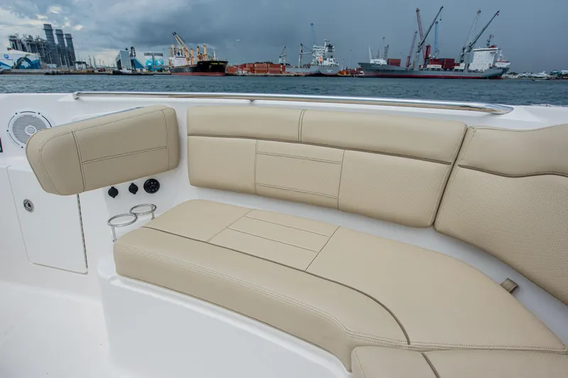 Southern Pass Yacht Photos Pics 2019 Pursuit S 328 Sport boat interior with beige seating, docked near industrial port.