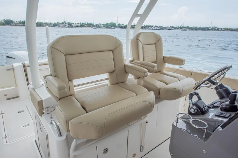 Southern Pass Yacht Photos Pics 2019 Pursuit S 328 Sport boat interior with beige captain seats and steering console.