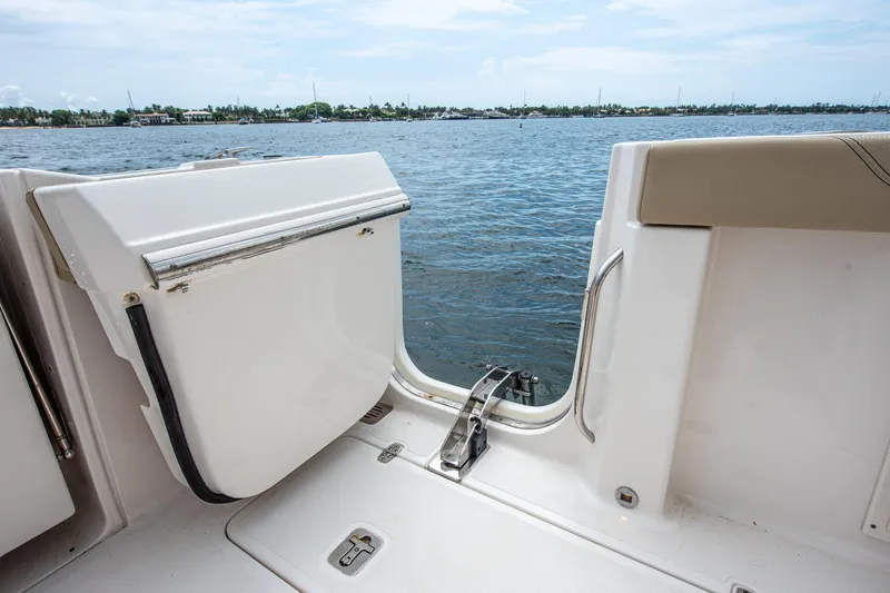 Southern Pass Yacht Photos Pics 2019 Pursuit S 328 Sport boat with open side door, overlooking calm waters.