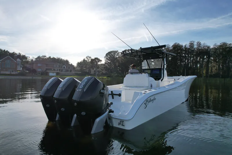  Yacht Photos Pics 2009 Yellowfin 36 Offshore boat with triple Mercury engines on a calm lake.