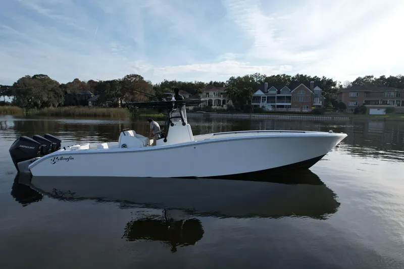  Yacht Photos Pics 2009 Yellowfin 36 Offshore boat on calm water, with houses in the background.