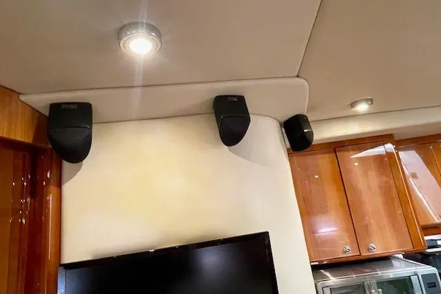 "just One Mohr" Yacht Photos Pics Interior of 2005 Regal Commodore 4260 yacht with mounted speakers and wooden cabinetry.