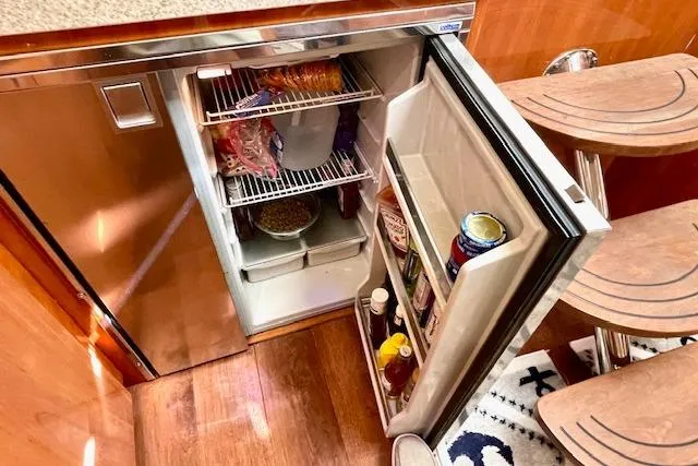 "just One Mohr" Yacht Photos Pics Open fridge inside 2005 Regal Commodore 4260 yacht, stocked with food and beverages.