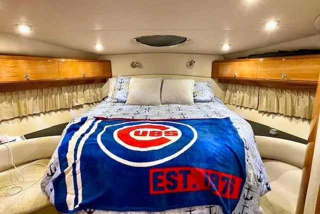 "just One Mohr" Yacht Photos Pics Luxurious 2005 Regal Commodore 4260 cabin with cozy bed and sports-themed blanket.