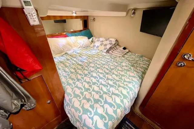 "just One Mohr" Yacht Photos Pics Cozy cabin interior of 2005 Regal Commodore 4260 with bed and TV.