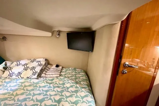 "just One Mohr" Yacht Photos Pics 2005 Regal Commodore 4260 cabin interior with bed, TV, and wooden door.