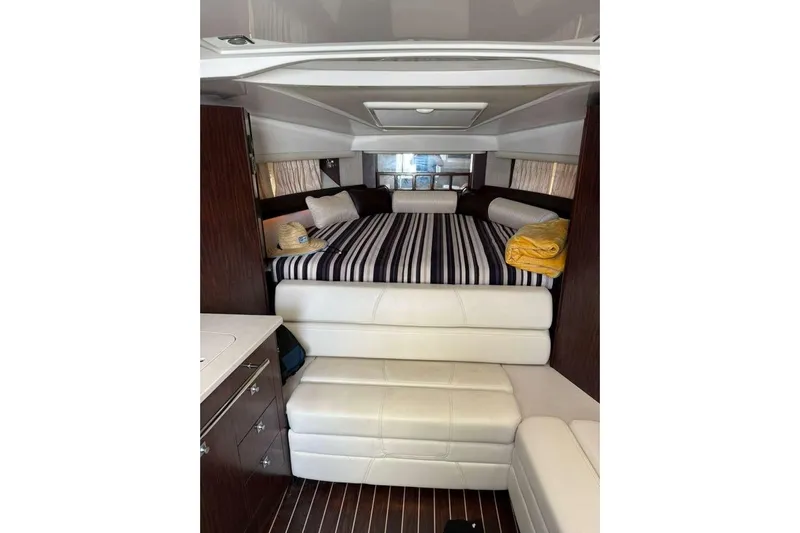  Yacht Photos Pics 2018 Monterey 335 Sport Yacht interior with striped bedding and modern furnishings.