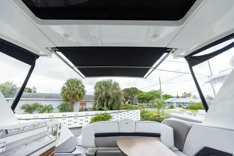  Yacht Photos Pics 2020 Four Winns H350 boat interior with seating and table, featuring a retractable sunshade.