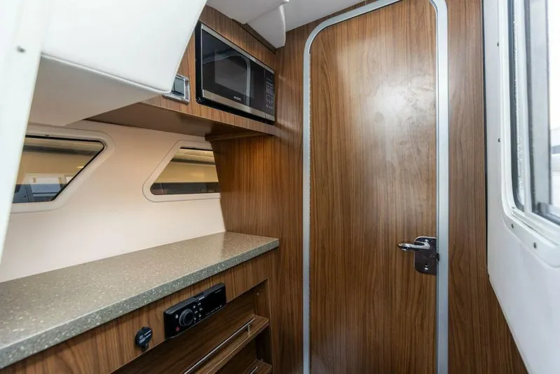  Yacht Photos Pics 2020 Four Winns H350 cabin interior with wood finish, microwave, and countertop.
