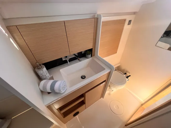 348 Sea Yacht Photos Pics Modern bathroom in 2026 Hanse 348 yacht with sink, toilet, and wooden cabinetry.