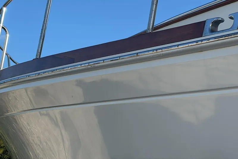 Tatosh Yacht Photos Pics Close-up of 1998 Grand Banks 43 Eastbay FB boat hull against blue sky.