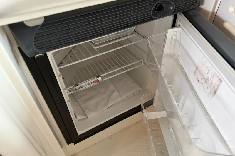  Yacht Photos Pics Open refrigerator inside a 2006 Sea Ray 40 Sundancer boat, showing empty shelves and door storage.