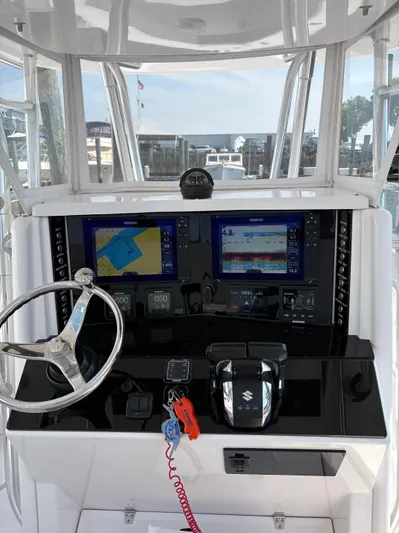  Yacht Photos Pics 2009 Venture 34 CC boat dashboard with navigation screens and steering wheel.