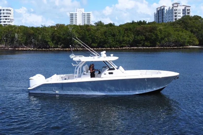 Perseverance Yacht Photos Pics 2019 Pursuit S 368 Sport boat cruising on a calm waterway with lush greenery.