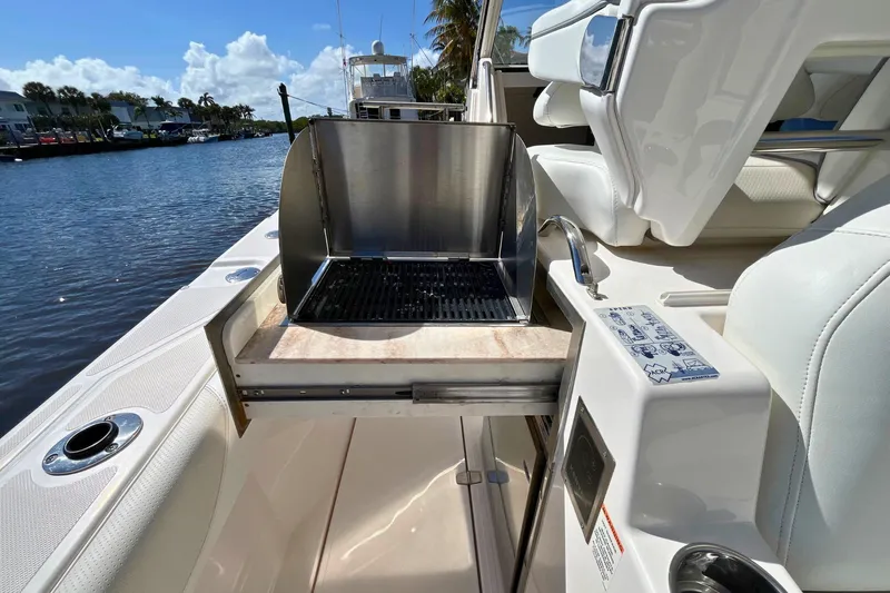 Perseverance Yacht Photos Pics 2019 Pursuit S 368 Sport boat with built-in grill on deck, docked by water.