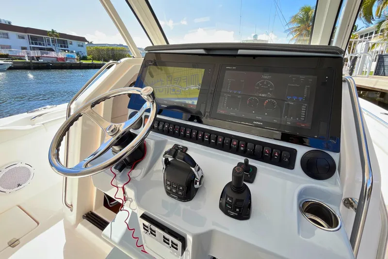 Perseverance Yacht Photos Pics 2019 Pursuit S 368 Sport boat dashboard with steering wheel and navigation display.
