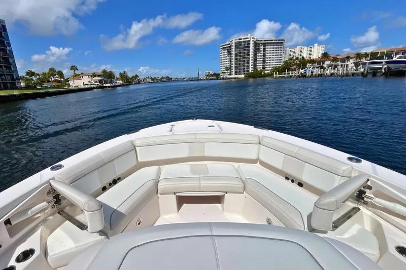 Perseverance Yacht Photos Pics 2019 Pursuit S 368 Sport boat on a scenic waterfront with buildings.