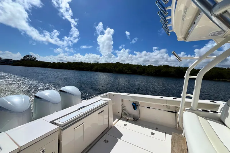 Perseverance Yacht Photos Pics 2019 Pursuit S 368 Sport boat on water, clear sky, lush shoreline in background.