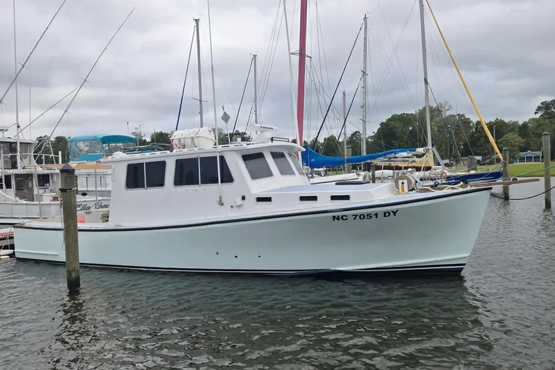 Sunrise Yacht Photos Pics 1995 MDI Downeast boat docked in a marina with sailboats in the background.