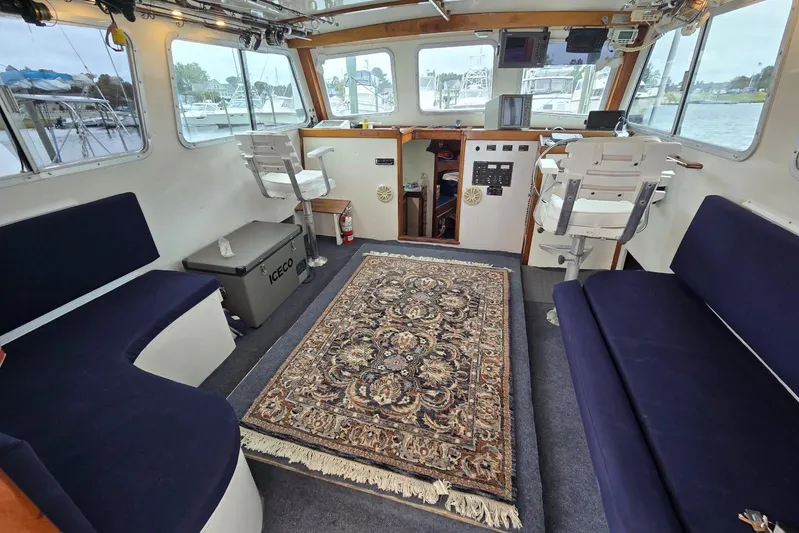 Sunrise Yacht Photos Pics Interior of 1995 MDI Downeast boat with seating, rug, and control panel.