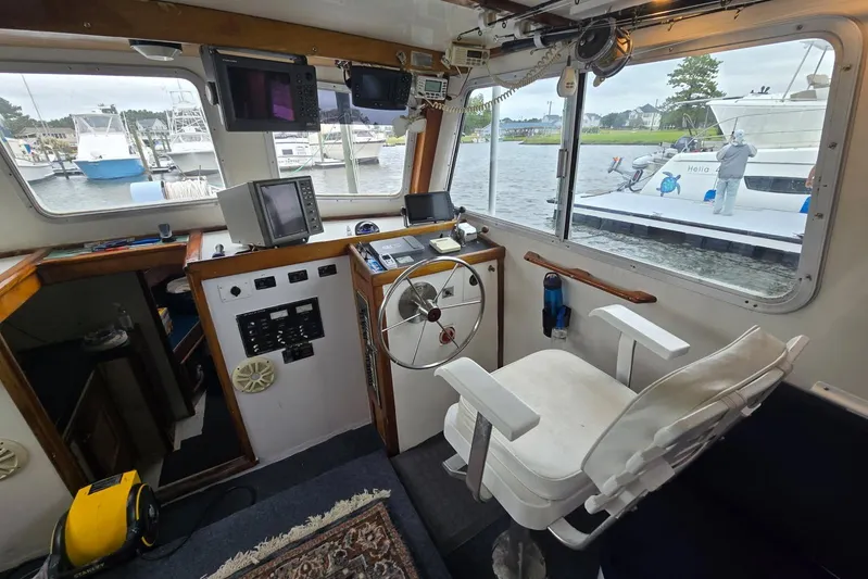 Sunrise Yacht Photos Pics Interior of a 1995 MDI Downeast boat with steering wheel and navigation equipment.