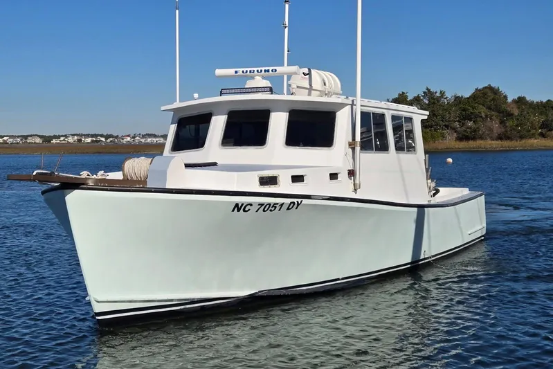 Sunrise Yacht Photos Pics 1995 MDI Downeast boat on calm water, featuring a white hull and cabin.