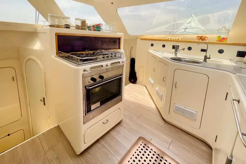  Yacht Photos Pics Compact kitchen in a 1998 Voyager Norseman 430 yacht, featuring stove, sink, and storage.