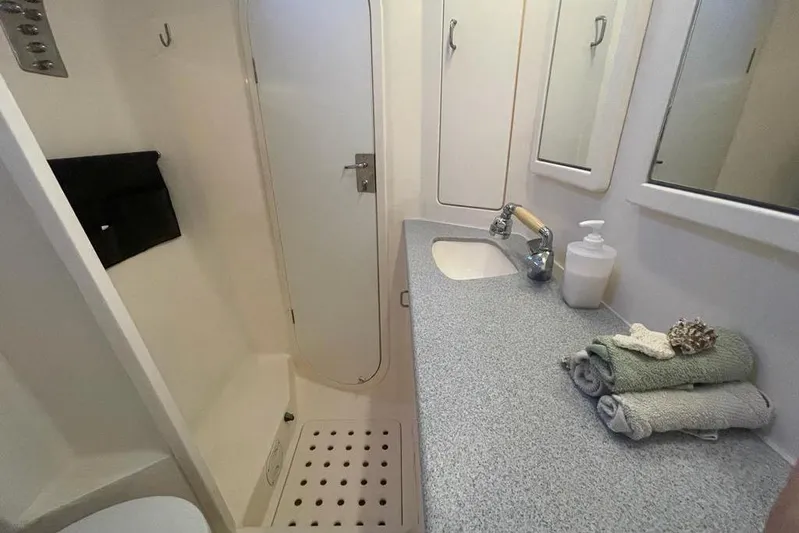  Yacht Photos Pics Compact bathroom in 1998 Voyager Norseman 430 yacht, featuring sink, towels, and shower area.