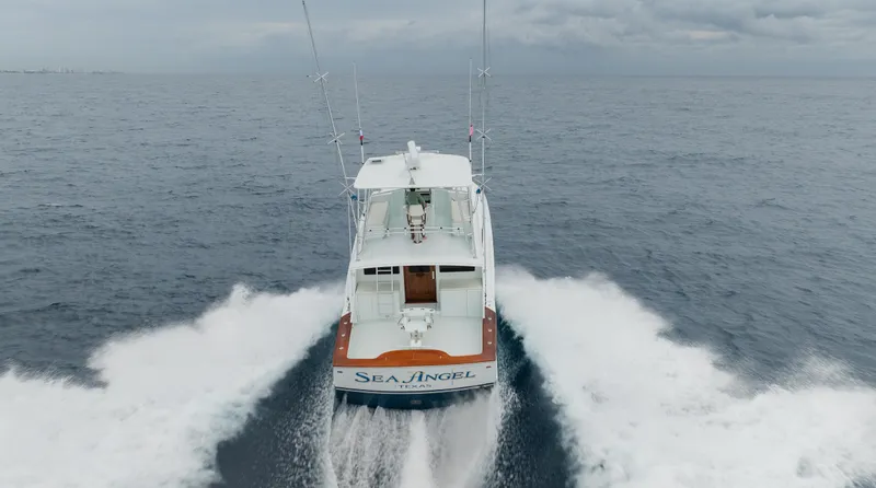 Sea Angel Yacht Photos Pics 1980 Scarborough 46 Convertible boat cruising on open sea, rear view.