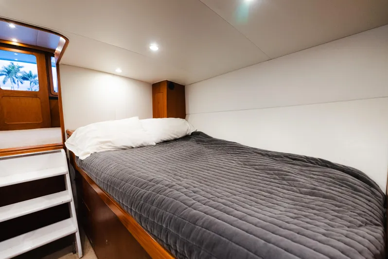 Sea Angel Yacht Photos Pics Cozy cabin interior of 1980 Scarborough 46 Convertible yacht with bed and wooden accents.