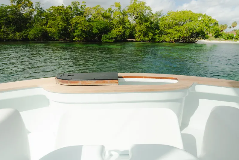 Sea Angel Yacht Photos Pics 1980 Scarborough 46 Convertible boat deck with scenic water and lush greenery backdrop.