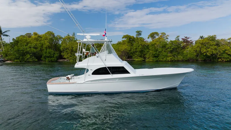 Sea Angel Yacht Photos Pics 1980 Scarborough 46 Convertible yacht on calm water, surrounded by lush greenery.