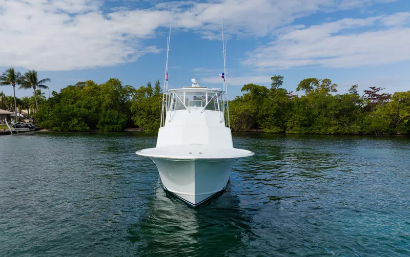 Sea Angel Yacht Photos Pics 1980 Scarborough 46 Convertible boat on water, surrounded by lush greenery and blue sky.