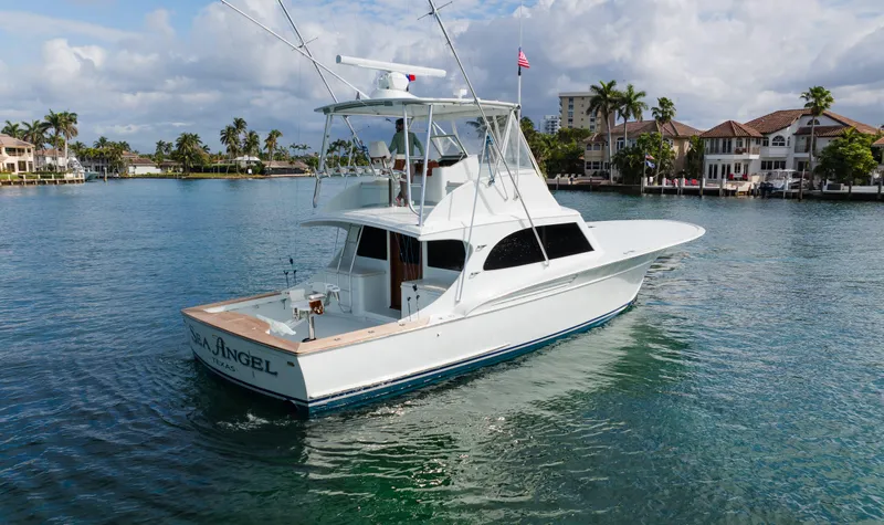 Sea Angel Yacht Photos Pics 1980 Scarborough 46 Convertible yacht on calm water, with coastal homes in the background.