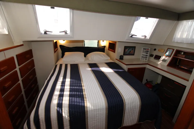 Gypsy Yacht Photos Pics Cozy bedroom in 2000 Ricker 42 Classic yacht with striped bedding and ample storage.