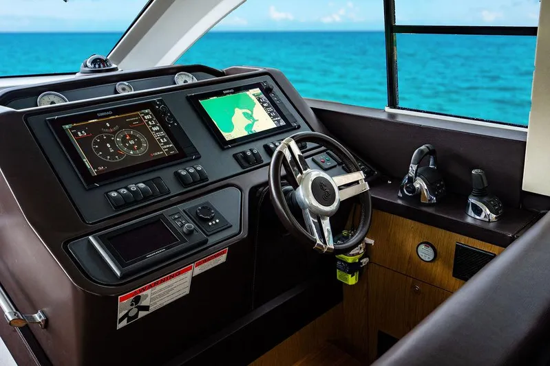 The Royal Blue Yacht Photos Pics 2015 Beneteau Gran Turismo 49 helm with navigation screens, steering wheel, and ocean view.