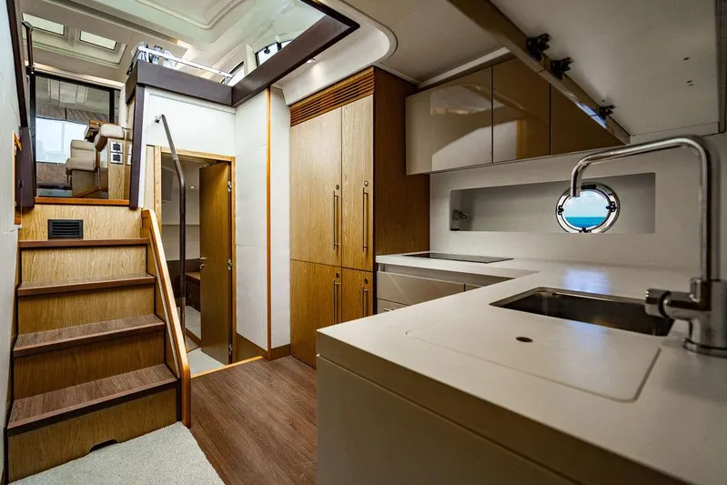 The Royal Blue Yacht Photos Pics Interior of 2015 Beneteau GRAN TURISMO 49 yacht, featuring modern kitchen and wooden stairs.