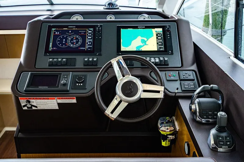 The Royal Blue Yacht Photos Pics Cockpit of 2015 Beneteau Gran Turismo 49 with navigation screens and steering wheel.