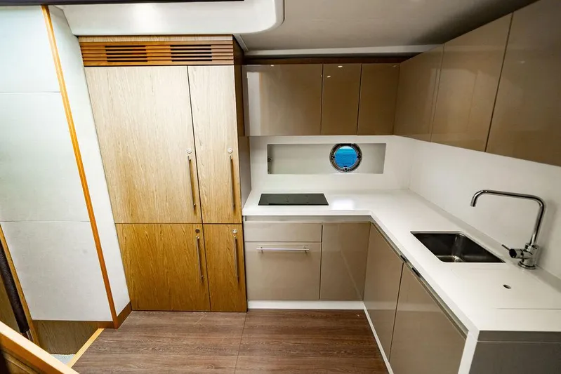 The Royal Blue Yacht Photos Pics Modern kitchen in 2015 Beneteau GRAN TURISMO 49 yacht with sleek cabinetry and porthole window.