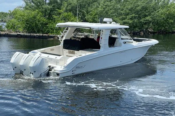 Yacht Photos Pics 2022 Boston Whaler 350 Realm boat cruising on a calm waterway.