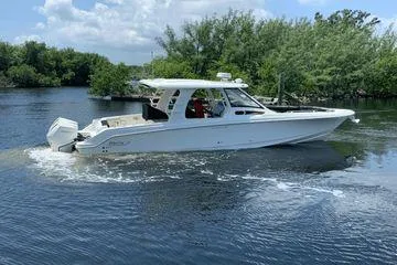  Yacht Photos Pics 2022 Boston Whaler 350 Realm boat cruising on a serene lake with lush greenery.