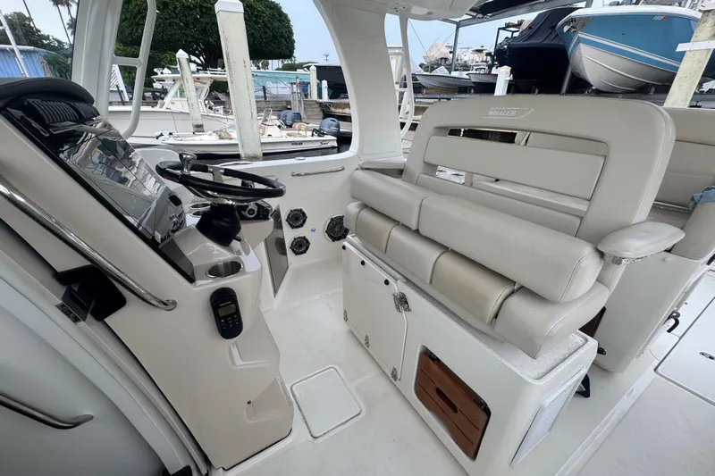  Yacht Photos Pics Interior view of 2022 Boston Whaler 350 Realm boat, featuring helm and seating area.