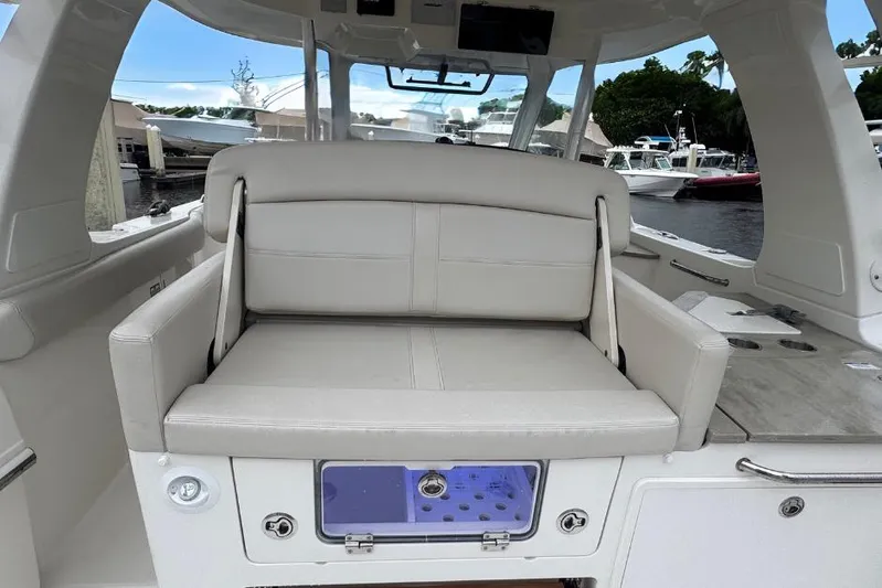  Yacht Photos Pics 2022 Boston Whaler 350 Realm interior with cushioned seating and storage compartment.