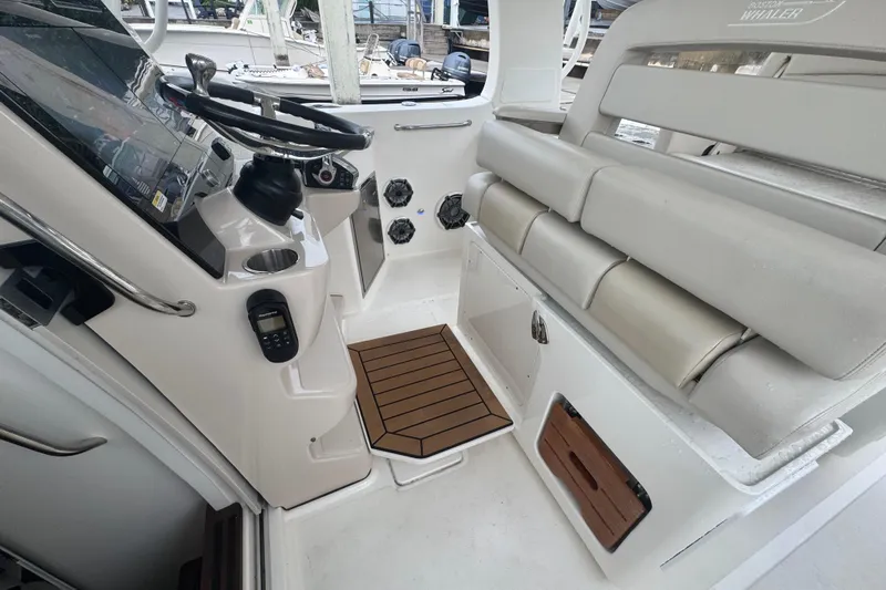  Yacht Photos Pics 2022 Boston Whaler 350 Realm cockpit with steering wheel, seating, and control panel.
