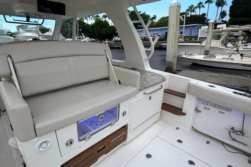  Yacht Photos Pics 2022 Boston Whaler 350 Realm interior with seating and storage, docked at marina.