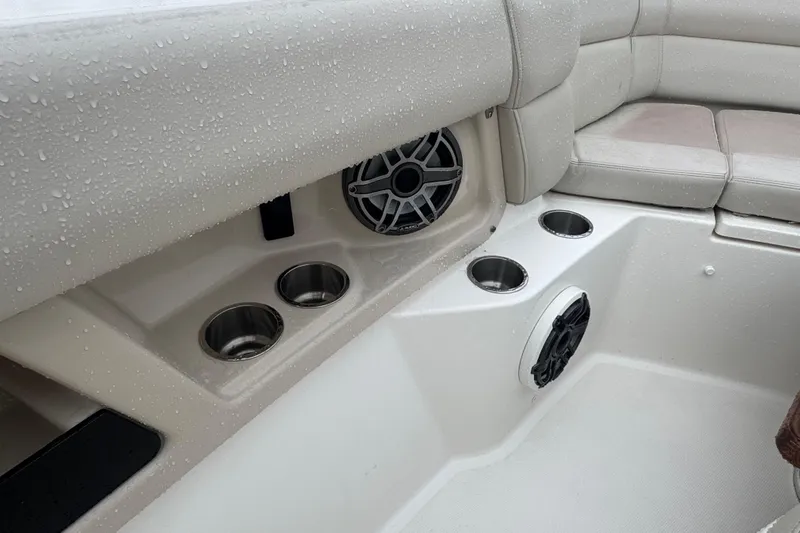  Yacht Photos Pics 2022 Boston Whaler 350 Realm interior with cup holders and speakers, wet from rain.