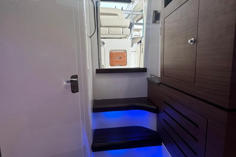  Yacht Photos Pics Interior view of 2022 Boston Whaler 350 Realm with illuminated steps and wooden cabinetry.